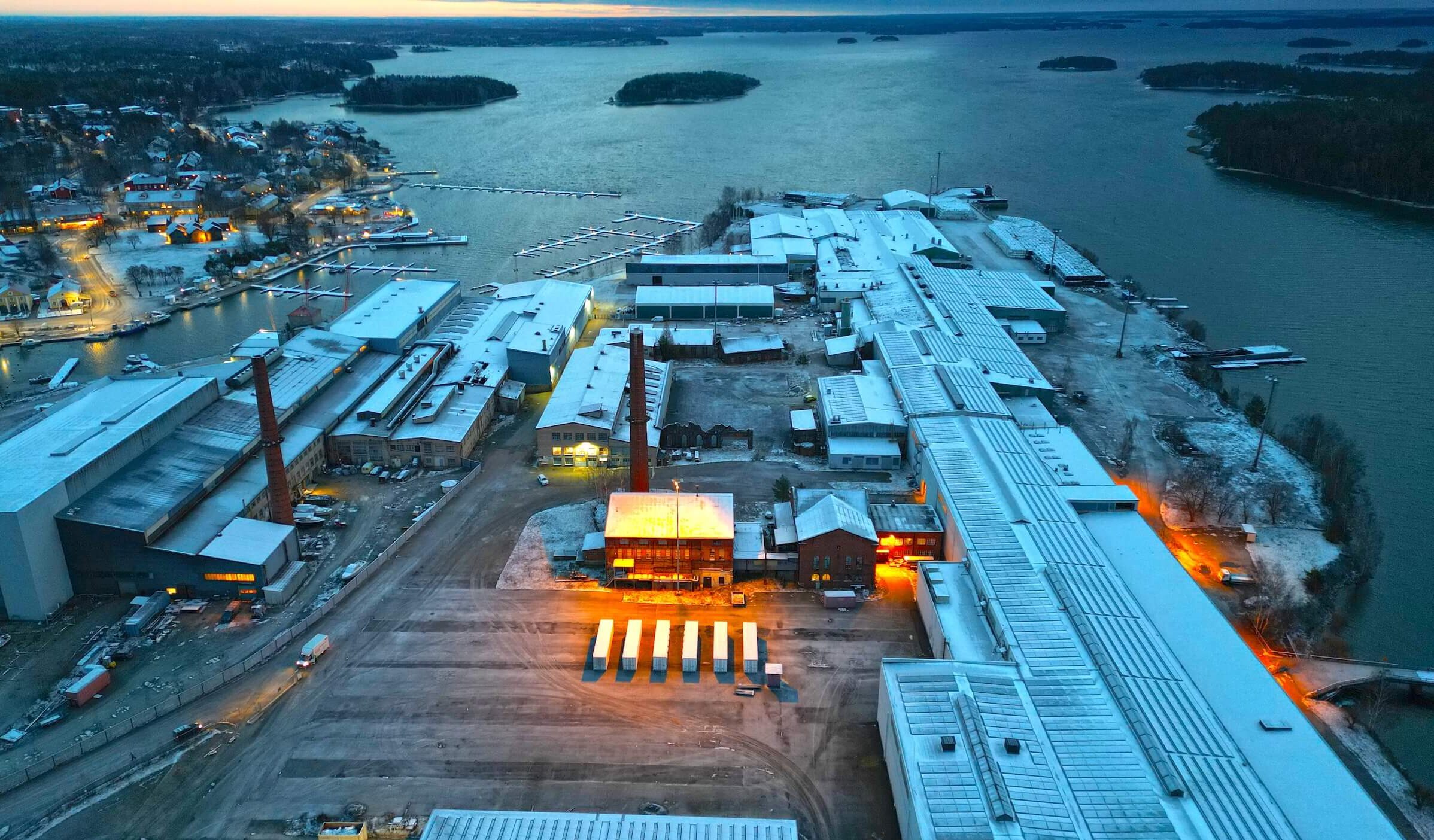 Archived aerial site view in Southern Finland, showing industrial buildings, coastline and evening light.